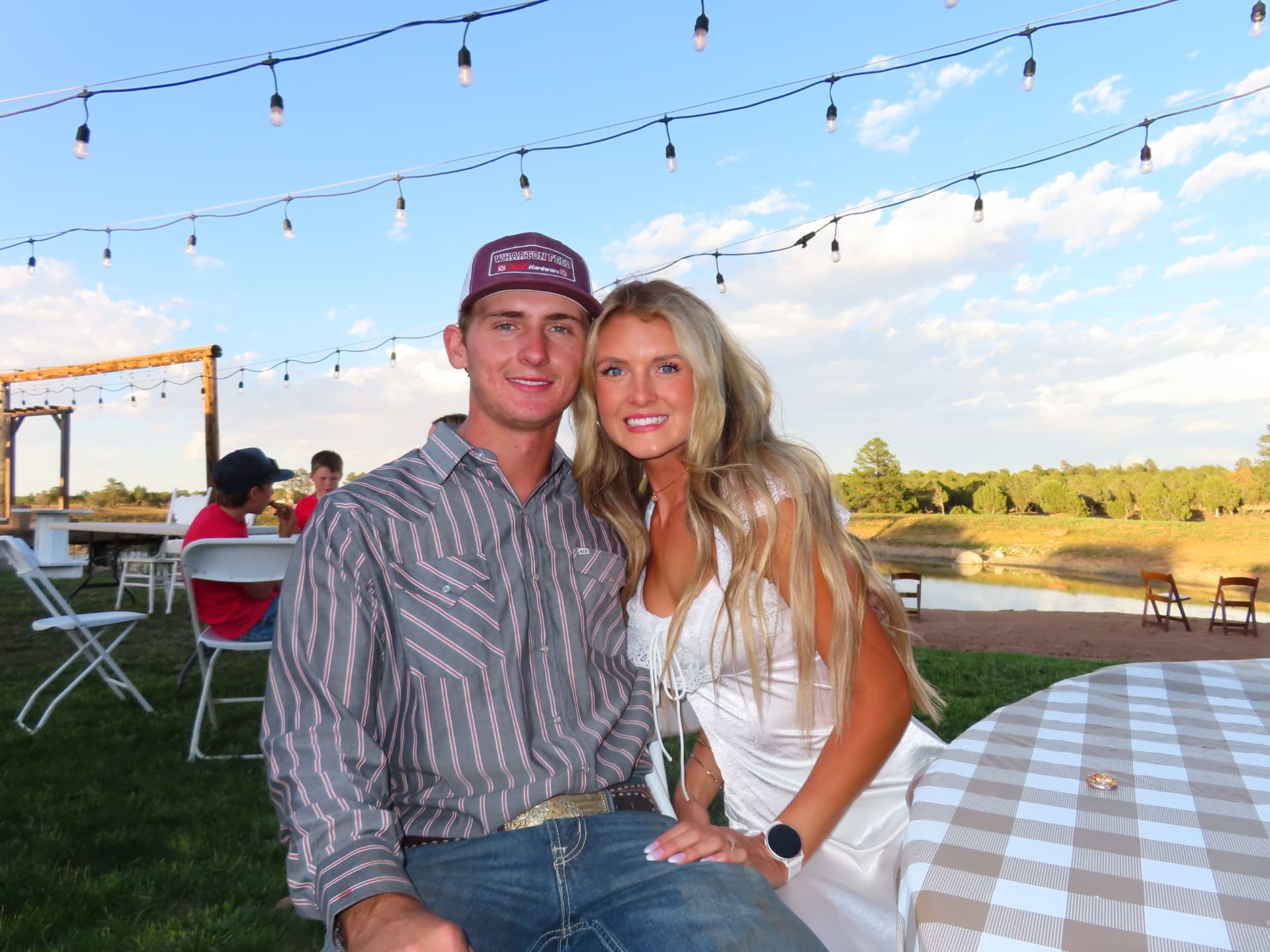 Jacey and Gage Reidhead at an outdoor celebration under string lights