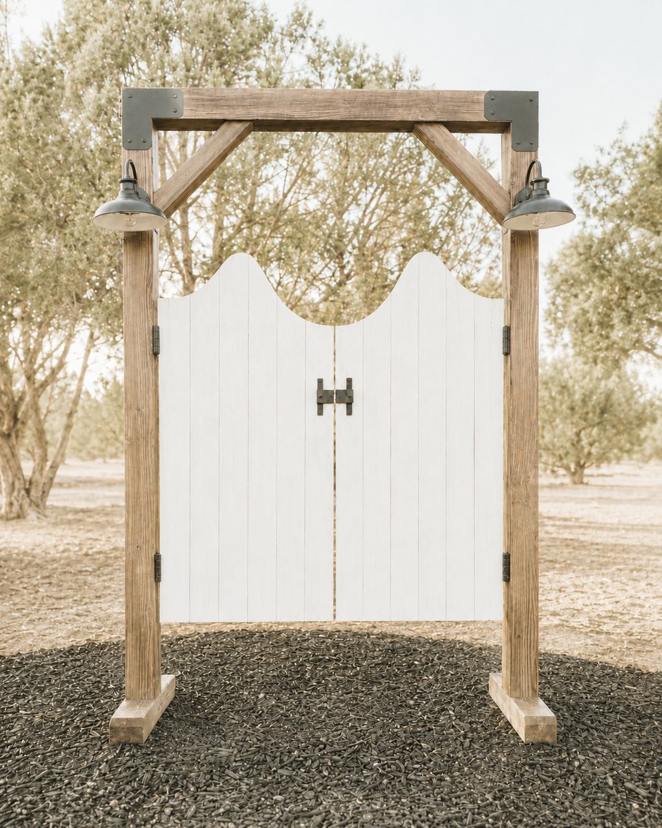 Handcrafted vintage-style white saloon doors backdrop on a rustic timber arch